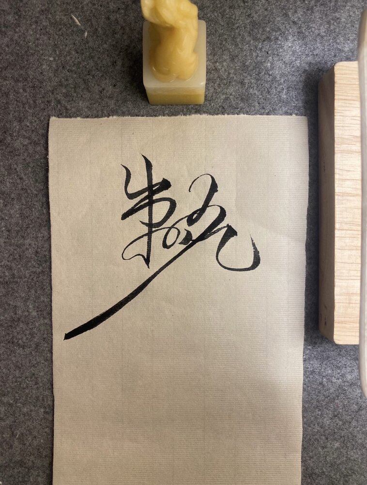 Brush calligraphy beside a carved stone seal